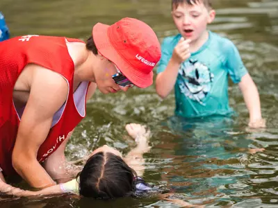 A swim instructor assisting a child in the water