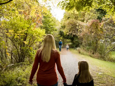 Woman and daughter walking on trail