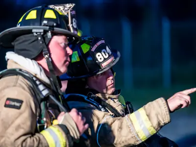 two firefighters pointing at something