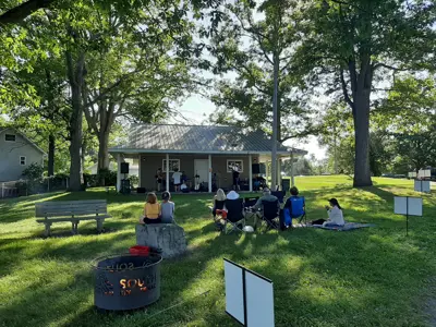 A band playing outdoors in front of people in lawn chairs
