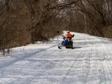 A person on a snowmobile on a snowy trail